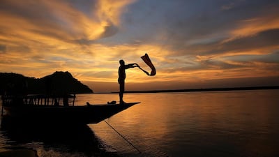 An Indian boat man dry his cloths at his boat after the day’s work at the banks of the Brahmaputra river during the sunset in Guwahati, India. Harish Tyagi / EPA