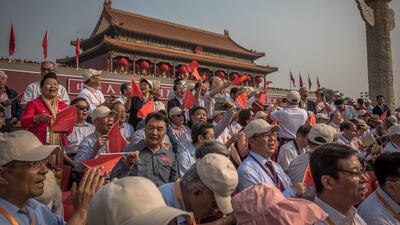 Visitors with Chinese flags sing at the military parade next to Tiananmen Square. EPA