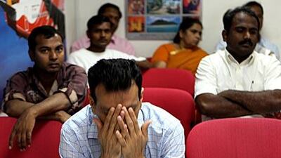 Relatives and friends of those aboard Flight 812 wait for news at the ticketing office of Air India Express in Deira, Dubai.