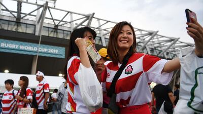 Fans pose for a selfie outside the Tokyo stadium. AFP