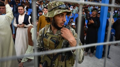 A Taliban fighter stands guard as spectators watch the Twenty20 cricket trial match in Kabul. AFP