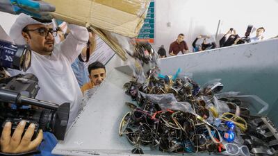 Ibrahim Behzad, director of the intellectual property protection division at DED, puts faker designer sunglasses through the shredding machine. Victor Besa for The National