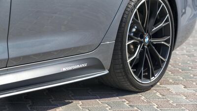 The BMW M550i has low-profile tyres and lowered suspension. Chris Whiteoak / The National