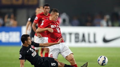 Huang Bowen of China's Guangzhou Evergrande, right, competes for the ball with Al Ahli's Walid Abbas during the Asian Champions League final in Guangzhou on November 21, 2015. AFP Photo