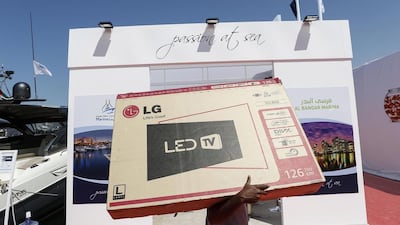 A staff carries a large-screen televison to be installed on a stand at the show. Antonie Robertson / The National