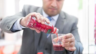Mahmoud Mahmoud, of Afghan Red Pomegranate, displays juice produce at Gulfood 2018. Afghan farmers are being offered incentives to grow pomegranate instead of poppies in a bid to stifle the country's drug trade. Reem Mohammed / The National