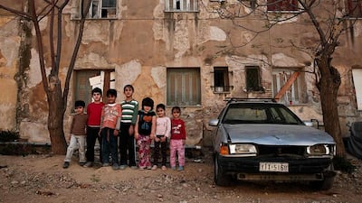 Immigrants pose in front of one of the buildings.