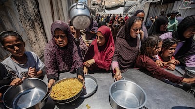 Displaced Palestinians in Gaza city wait for hot meals at a charity kitchen. The campaign for protests said it was motivated by Gazans' suffering. EPA