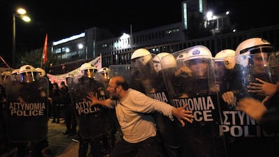 A protester tries to stop riot police during a demonstration in Athens, Greece, earlier this month. The country has suffered from ever-widening deficits as Germany’s economy has recovered. Kostis Ntantamis / AFP