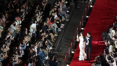 South Korean actor Jung Woo-sung (R) and actress Lee Honey (L) walk on the red carpet during the opening ceremony of the 24th Busan International Film Festival. EPA
