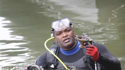 A huge underwater clean-up operation has recovered 1.3 tonnes of waste and litter from a lagoon in central Sharjah. Basheer Yousef Al Hamadi from the Sinan Voluntary team salvages the heaviest item: a rusty bicycle. Courtesy Sharjah Museums Department