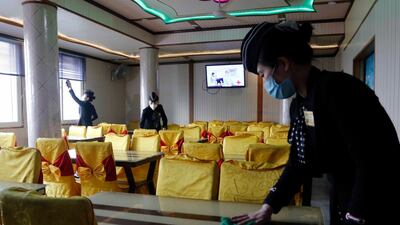 Staff of the Pongnam Noodle House disinfect the tables and windows of the restaurant in Pyongyang. AP Photo