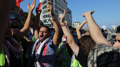 People wave Lebanese flags and chant to mark the first anniversary of anti-government protests. Getty Images