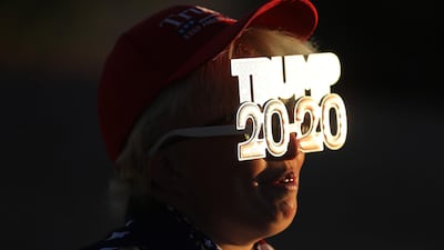 Tara Immen of Happy Valley, Arizona, wears decorative glasses while waiting in line to attend a campaign rally with U.S. President Donald Trump at Phoenix Goodyear Airport. AFP