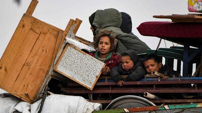 Children ride in the back of a lorry loaded with household goods in the west of Syria's Aleppo province as civilians flee advancing Syrian government forces. AFP