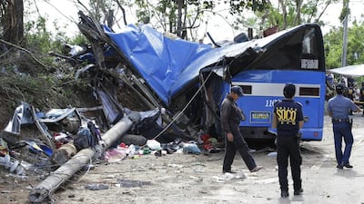 Police investigators stand beside the wreckage of a bus that crashed on a downhill road in Tanay, Rizal province, east of Manila, Philippines, on February 20, 2017. More than a dozen people - mostly college students - were on their way to camp when their rented bus lost control of its brakes on the downhill road and slammed into a post, town officials said. Aaron Favila/AP Photo