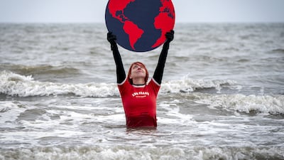 Susie Gray from the Edinburgh Science Festival team stands in the Firth of Forth at Portobello, Edinburgh, holding a giant black and red Earth to highlight the climate emergency and rising sea levels. PA Photo