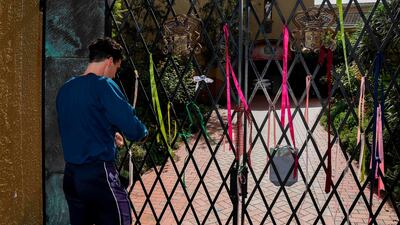 A man ties a ribbon in solidarity with abuse victims on the gate to the Carmelite Monastery in Melbourne on April 8, 2020, where Cardinal George Pell is staying after he was released the day before from prison after Australia's High Court quashed his conviction for abuse. AFP