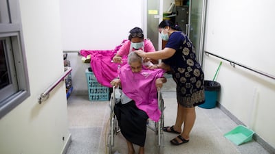 A Thai elder receives a haircut by caregivers at the Elderly Home Ban Bang Khae II in Bangkok. EPA