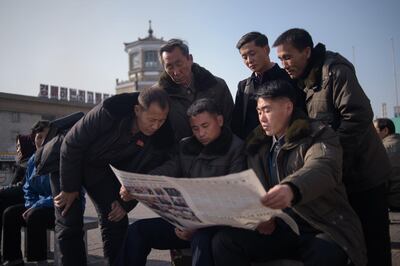 People read the Rodong Sinmun newspaper showing coverage of North Korea's leader Kim Jong Un visit to Vietnam in a public square in Pyongyang. AFP