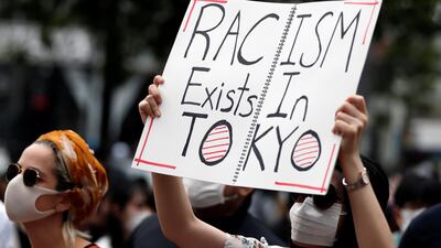 A demonstrator wearing a mask holds a placard during a protest march over the alleged police abuse of a Turkish man, in echoes of a Black Lives Matter protest, following the death of George Floyd who died in police custody in Minneapolis, in Tokyo, Japan. Reuters