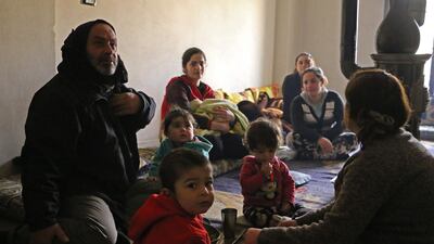 Members of seven displaced Syrian families gather in an apartment in the Kurdish Syrian town of Afrin on February 1, 2018. Ahmad Shafie / AFP