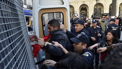 Algerian policemen detain protesters after they demonstrated at Emir Abdelkader square in the capital Algiers. AFP