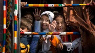 Pakistani children peek out of a bus as they leave school in Wajah Khiel, Swat Valley, Pakistan. Anja Niedringhaus / AP Photo