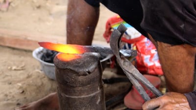 Yemeni blacksmiths hammer metal salvaged from fallen rockets in air strikes to create blades for new daggers. All photos AFP Photo