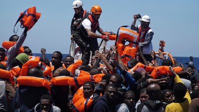 Migrants are rescued from a dinghy in the Mediterranean Sea by members of the medical aid group Medecins Sans Frontieres and the rescue group SOS Mediterranee. Bram Janssen / AP Photo