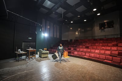 Theatre manager Tariq Al Shawa shifts furniture at the theatre as it is readied for reopening as a cinema. Majd Mohamad for The National
