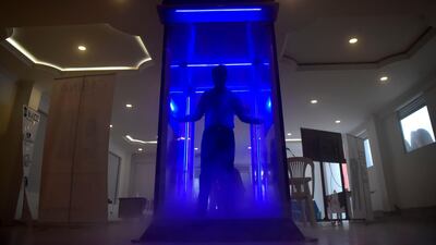 A man performs during the presentation of an automatic disinfection cabin that would help fight the coronavirus, in Bogota. AFP