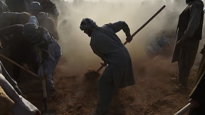 Men shovel soil on top of the graves of villagers who died in extreme heat in the deserts of south-western Afghanistan's Nimroz province, while attempting to cross into Iran. AFP