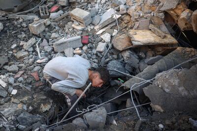A youth searches for survivors at the site of an Israeli strike on a family home in Deir Al Balah in central Gaza on Sunday. AFP