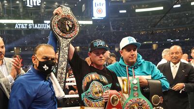 Saul Alvarez lifts the belts after defeating Billy Joe Saunders who did not answer the bell for the eighth round in their super middleweight title fight. AFP