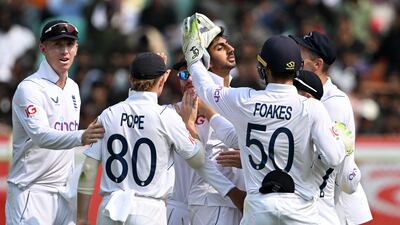 England bowler Shoaib Bashir, centre, celebrates with teammates after taking the wicket of India captain Rohit Sharma - the spinner's first in Test cricket. AFP