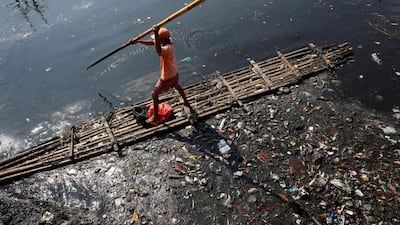 A worker gathers plastic and other debris from the Sekretaris River in Jakarta, Indonesia. Darren Whiteside / Reuters
