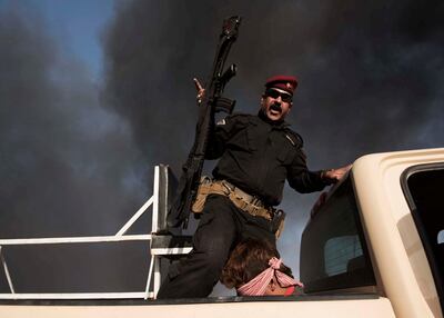 An Iraqi army soldier gestures with his rifle above Ali, 24, from Baaker, accused of being an ISIS member who tried to flee Mosul on October 31, 2016. Photo by Alessio Romenzi