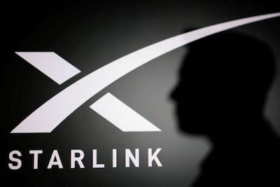 The silhouette of Elon Musk and the Starlink logo. Reuters