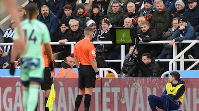 Robert Jones checks the VAR screen before giving a penalty to Fulham. Getty