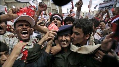 A Yemeni army officer, centre, is kissed by an anti-government protestor during a demonstration on March 25 in Sana'a.