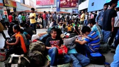 Hundreds of fearful migrant students and workers from north-eastern part of Assam gather at the Bangalore railway station after a rumour of possible violence spread.