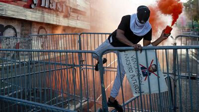 A protester scales barricades during a rally against copper mining outside the National Assembly in Panama City, Panama. EPA
