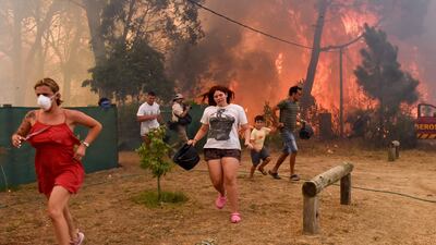 People flee from flames in La Floresta, Uruguay, where a wildfire was fanned by intense winds and dry conditions. EPA