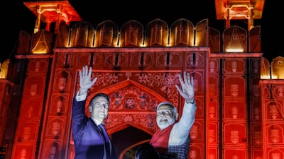 India's Prime Minister Narendra Modi (R) and France's President Emmanuel Macron wave from atop a vehicle as they at Rambagh Palace at the end of a roadshow in Jaipur on January 25, 2024. AFP