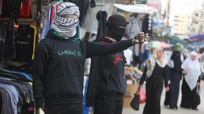 A mannequin holding a knife and wearing a jacket that reads: "Stab!" (L) is seen outside a clothes shop in Khan Younis, in the southern Gaza Strip. Ibraheem Abu Mustafa / Reuters