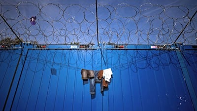 Clothes hang on barbed wires at a makeshift refugee and migrants camp near the Serbian town of Horgos, which is close to the border with Hungary, on September 29, 2016. The flow of migrants through the Balkans toward western Europe has continued despite the closure of the 'Balkan route' in March. More than 5,000 migrants have been stranded in Serbia looking for ways to cross to EU member states of Hungary and Croatia. Andrej Isakovic / Agence France-Presse