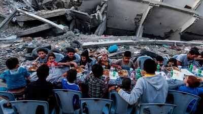 Palestinian families break their fast next to a destroyed building during recent confrontation between Hamas and Israel, in the Gaza Strip. AFP