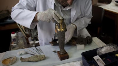 An Egyptian restorer fixes an artefact that was broken by looters at the Egyptian Museum in Cairo. The pillaging has been going in full-force since the country’s uprising in 2011. Emilio Morenatti / AP Photo