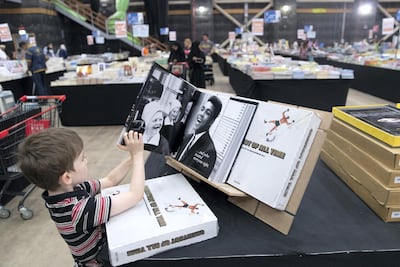 A young child reads a book during the opening day of the Big Bad Wolf Book Sale. Reem Mohammed / The National